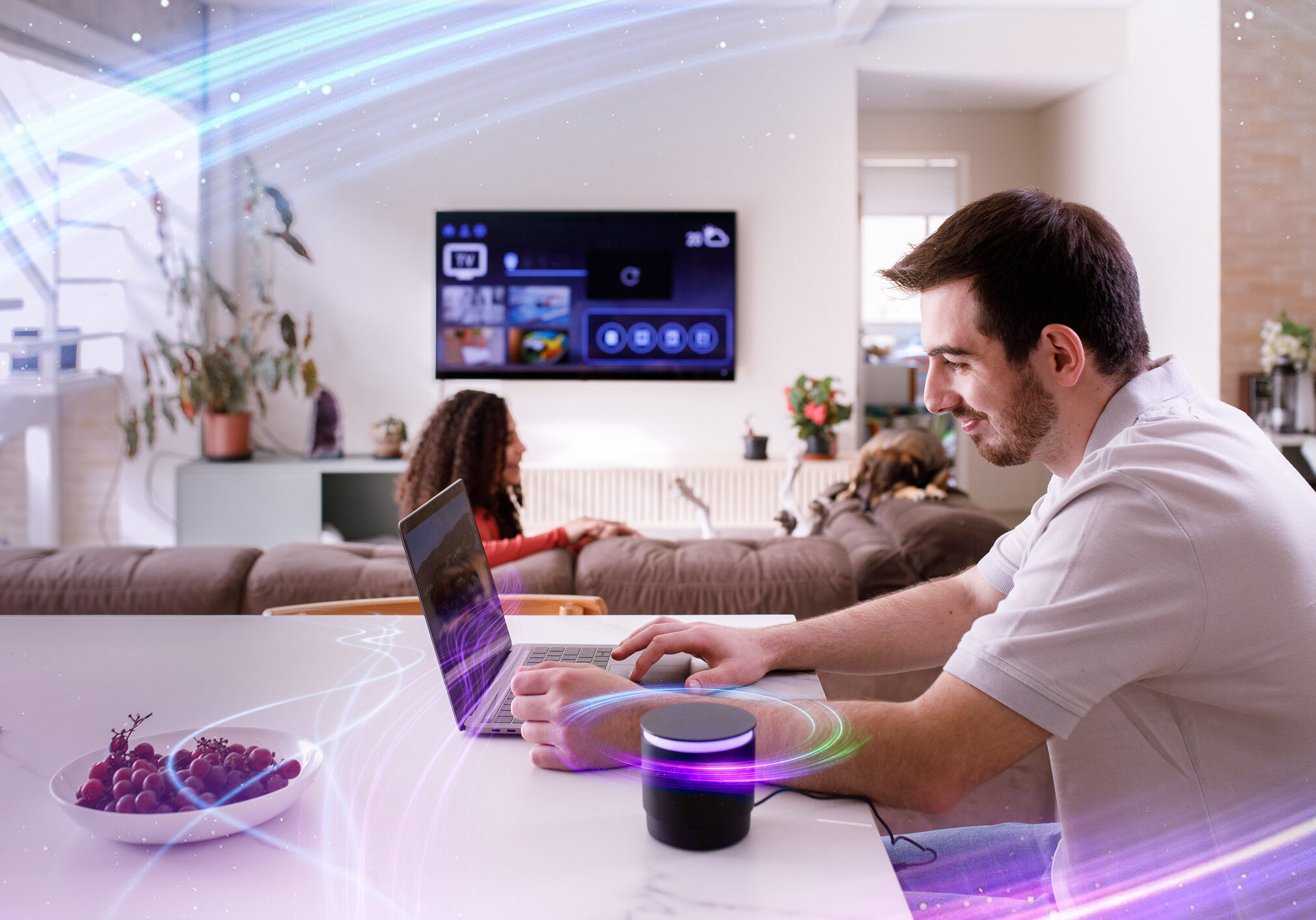 Man using laptop with smart speaker nearby