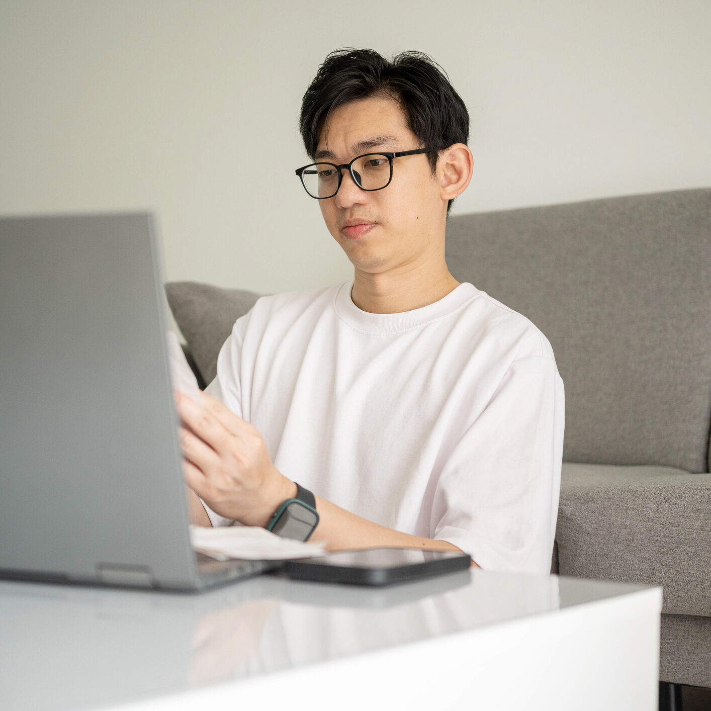 A modern remote worker analyzing contracts and business documents in a comfortable home office setup.
